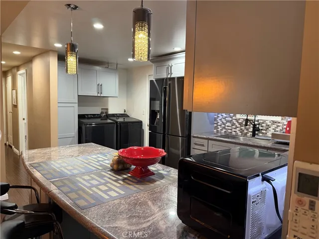 a kitchen with a table chairs and refrigerator