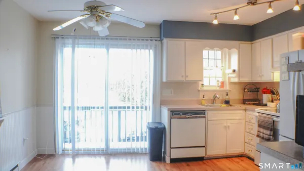 a kitchen with a refrigerator a sink and white cabinets