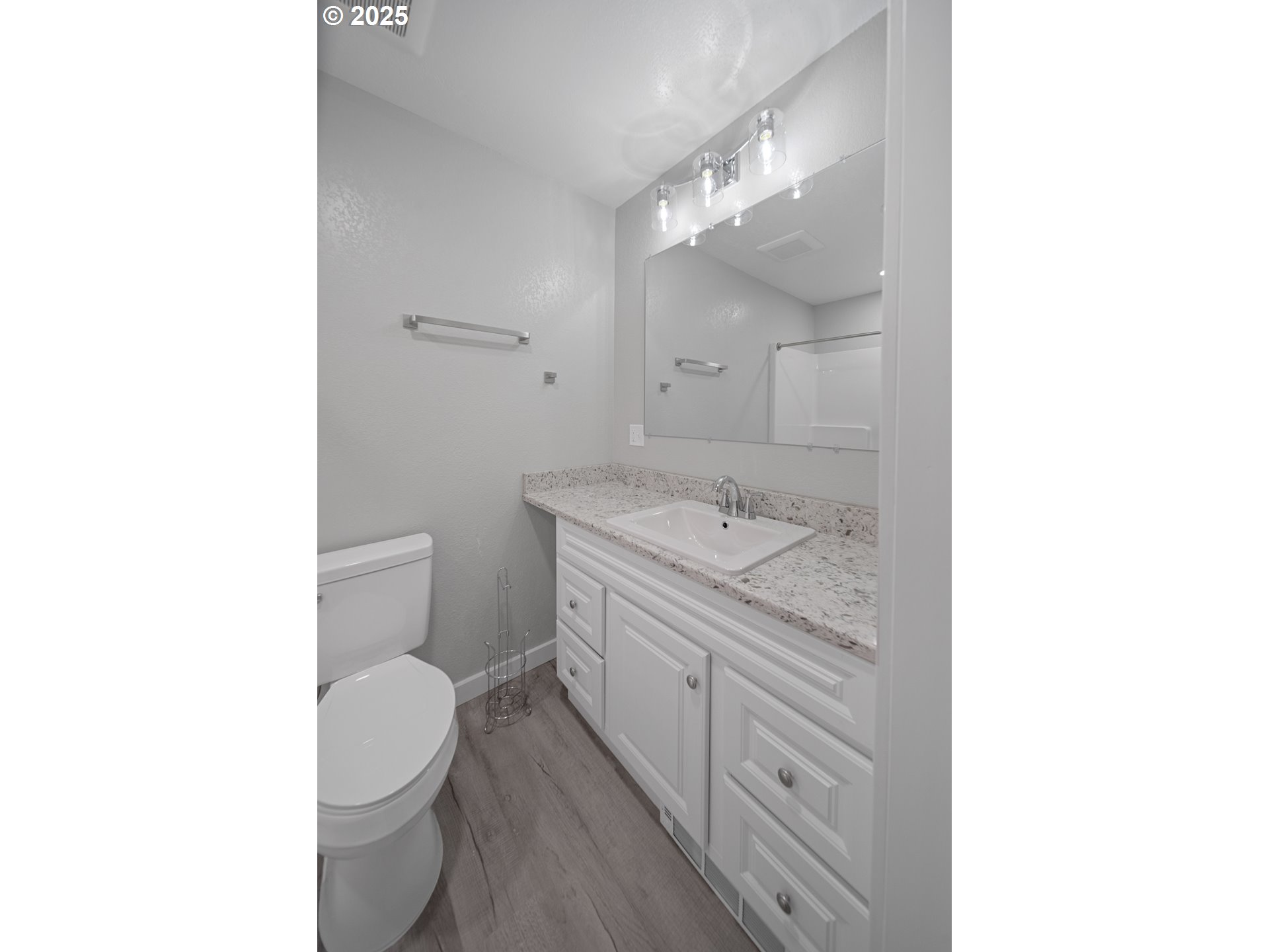 680-682 Elm Avenue Reedsport, OR 97467 - Photo 27 of 36 a spacious bathroom with a granite countertop sink a toilet and a mirror