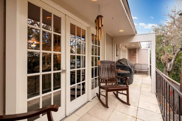 a tree in front of a brick house with a large tree