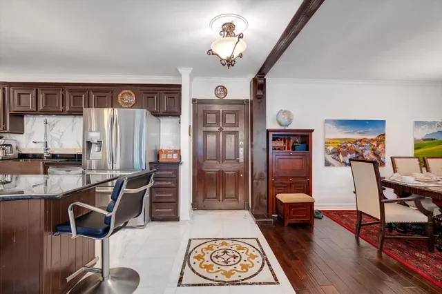a living room with furniture a dining table and a refrigerator