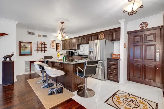 a view of a dining room with furniture a chandelier and wooden floor