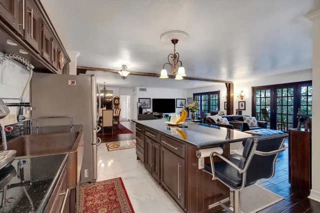 a living room with furniture dining table a flat screen tv and a large window