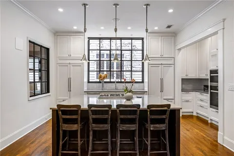 a kitchen with granite countertop a stove a sink and a refrigerator