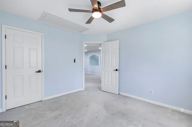 an empty room with chandelier fan