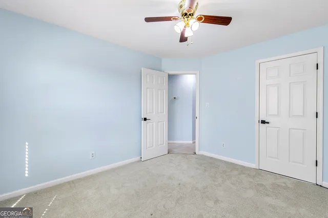 an empty room with a chandelier fan
