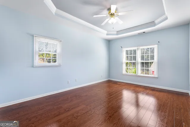 a view of an empty room with a window and wooden floor