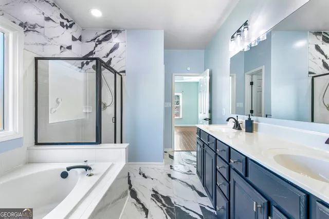 a bathroom with a tub a sink and a mirror