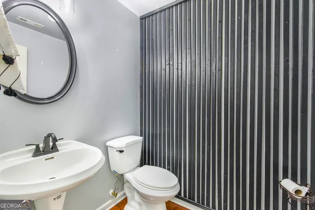 a white toilet sitting next to a bathroom sink