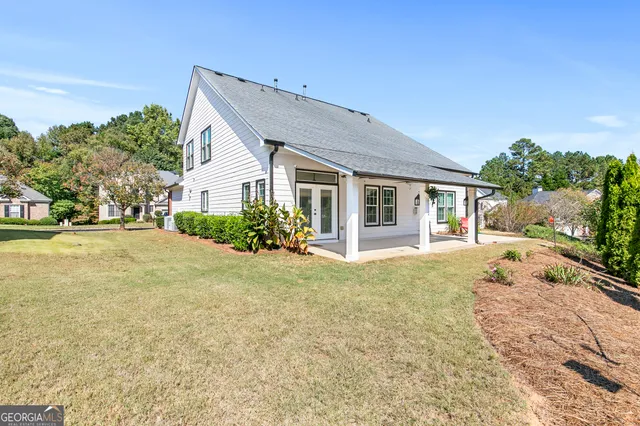 a house with yard and a trees in front of it