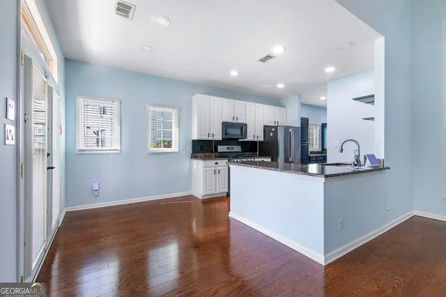a kitchen with stainless steel appliances granite countertop a refrigerator sink and cabinets