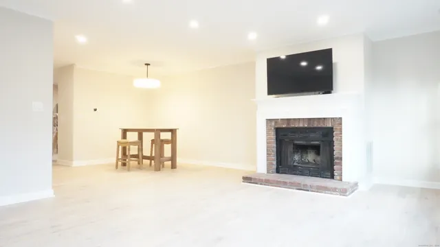 a view of an empty room with a fireplace and a window