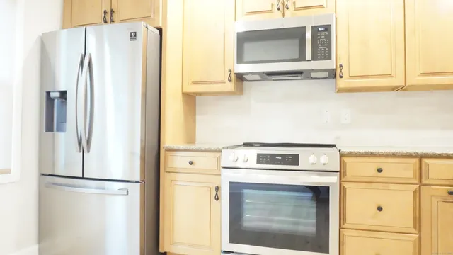a kitchen with stainless steel appliances white cabinets and a stove top oven
