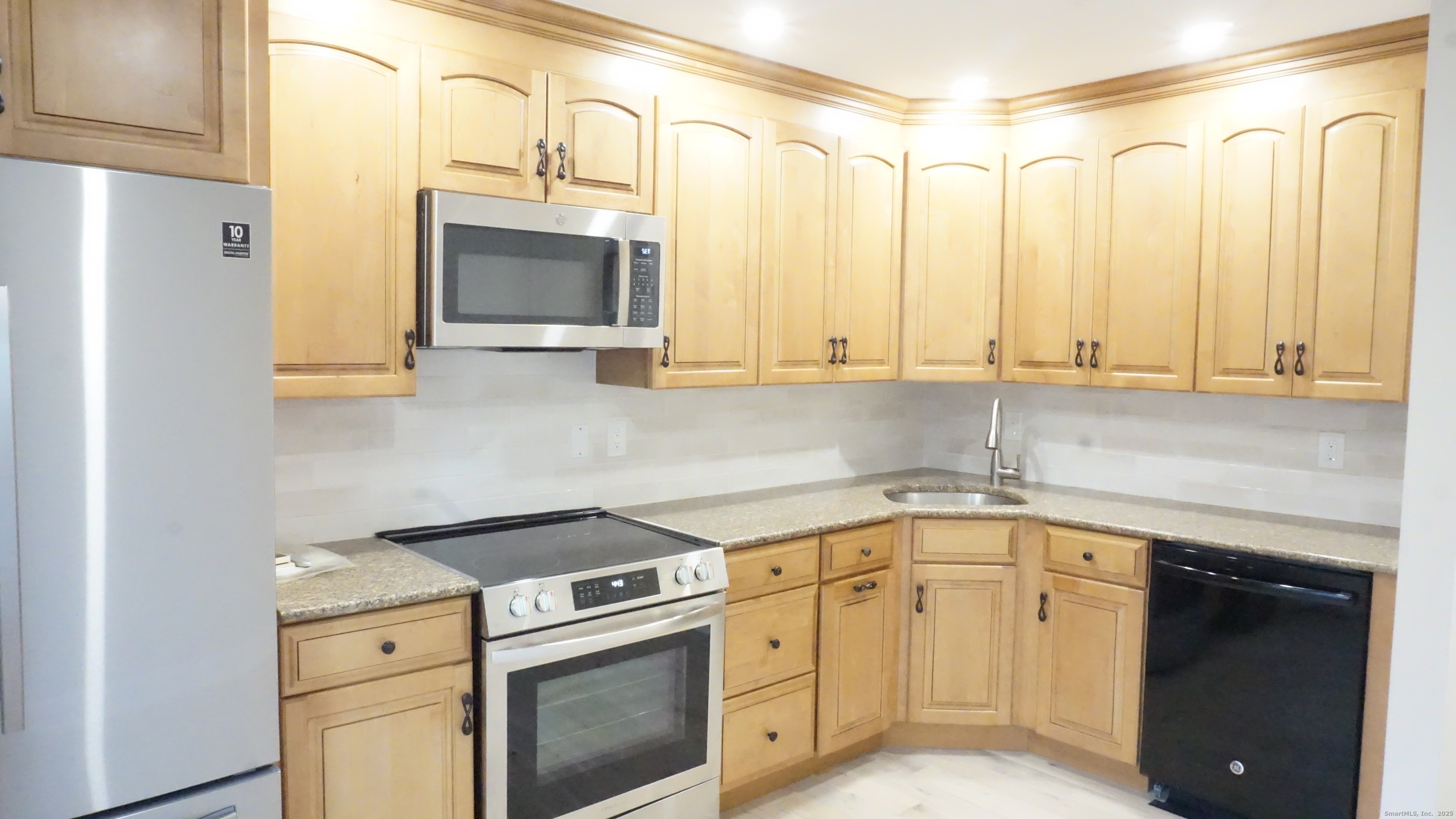 24 Overlook Drive, Unit 24 Monroe, CT 06468 - Photo 7 of 32 a kitchen with stainless steel appliances white cabinets and a stove top oven