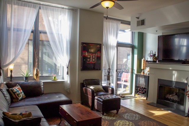 1201 West Adams Street, Unit 709 Chicago, IL 60607 - Photo 3 of 16 a living room with furniture a fireplace and a flat screen tv