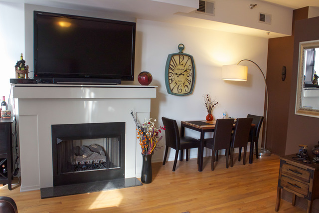 1201 West Adams Street, Unit 709 Chicago, IL 60607 - Photo 6 of 16 a living room with furniture a flat screen tv and a fireplace