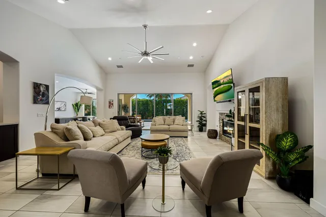 a living room with furniture a chandelier and a flat screen tv