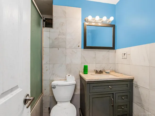 a bathroom with a toilet sink and mirror