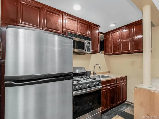 a kitchen with granite countertop a stove top oven microwave and cabinets
