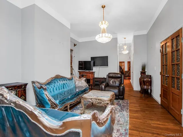 a living room with furniture chandelier and flat screen tv