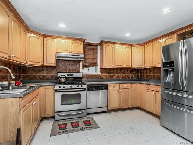 a kitchen with stainless steel appliances granite countertop a stove a sink and a refrigerator