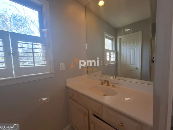 a bathroom with a sink shower and a mirror
