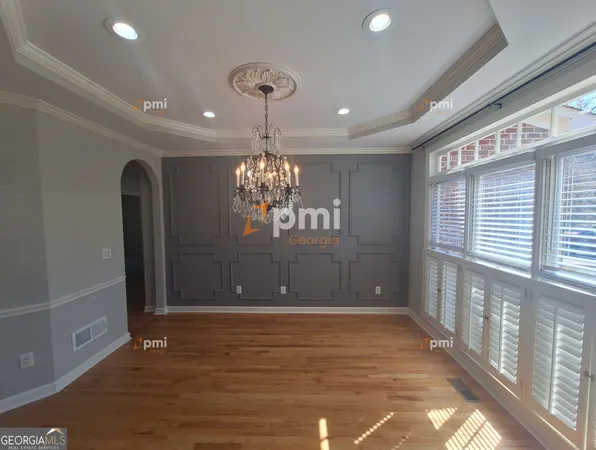 a view of a room with chandelier and wooden floor