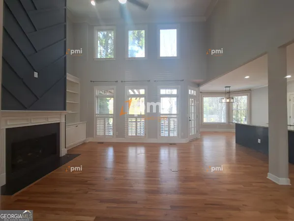 a view of an empty room with wooden floor and a fireplace