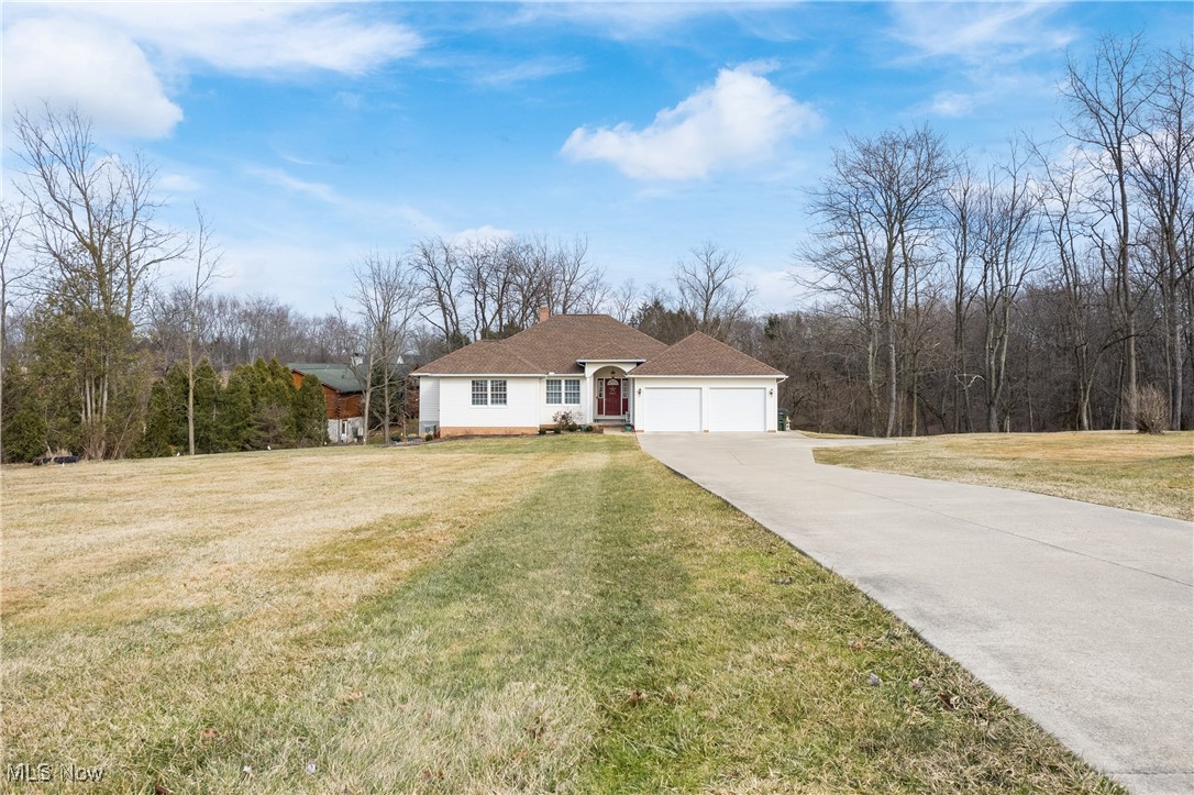 3393 Friendsville Road Wooster, OH 44691 - Photo 2 of 34 View of front of house featuring a garage, concrete driveway, a front lawn, and a chimney