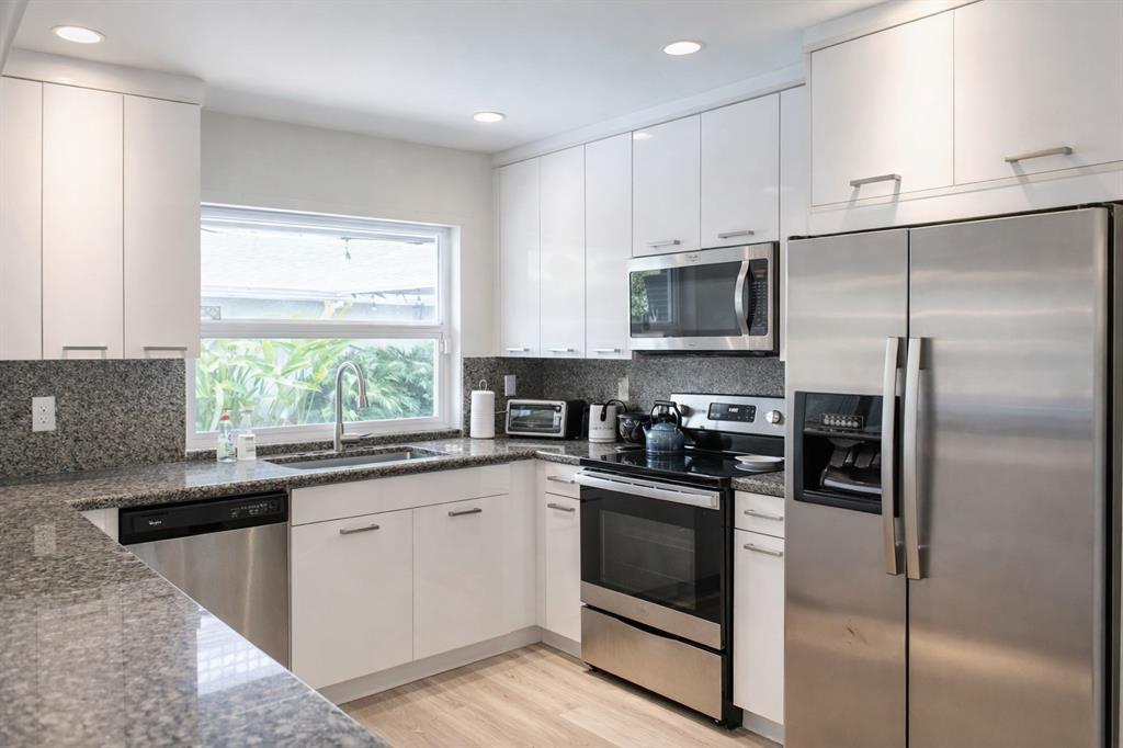 126 Laurel Road Hollywood, FL 33021 - Photo 5 of 16 a kitchen with white cabinets stainless steel appliances and a window