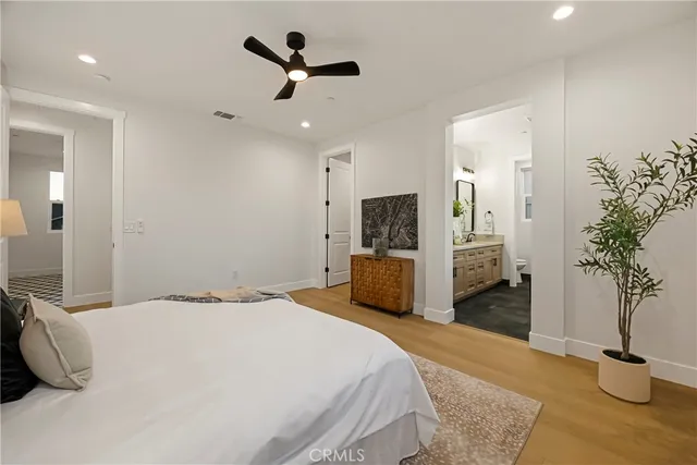 a spacious bedroom with a bed and a potted plant