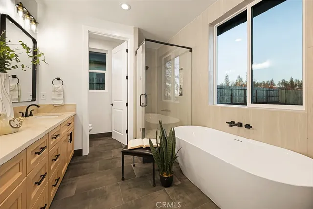 a spacious bathroom with a double vanity sink a mirror a a bathtub and a shower