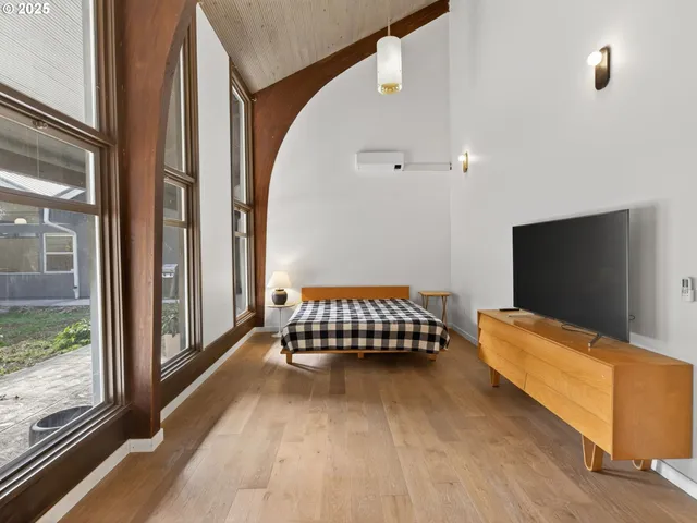 a living room with a bed and a flat screen tv