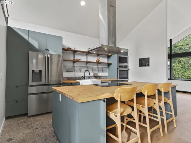 a dining room with furniture large windows and wooden floor