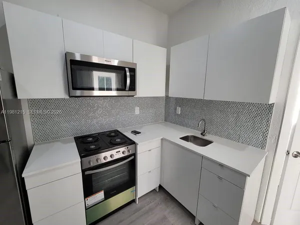 a kitchen with stainless steel appliances a sink stove and microwave
