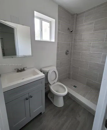 a bathroom with a sink toilet a mirror and shower