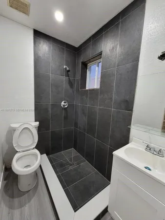 a bathroom with a toilet a sink a shower and mirror