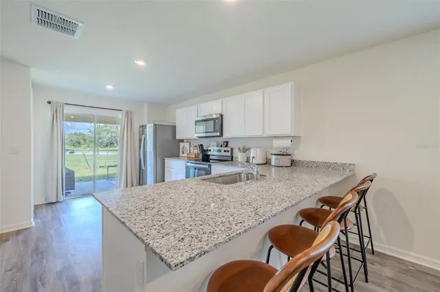 a kitchen with granite countertop kitchen island wooden cabinets and stainless steel appliances