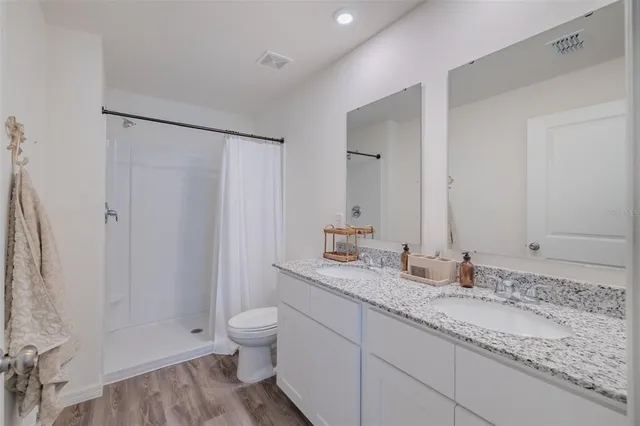 a bathroom with a granite countertop sink toilet and shower