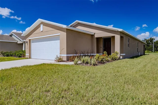 a front view of house with yard and garage