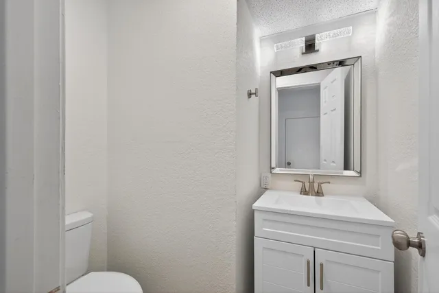 a bathroom with a sink a toilet and mirror