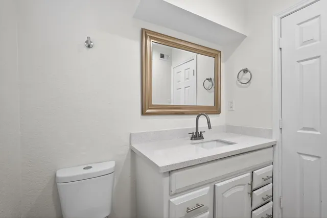 a bathroom with a toilet sink and mirror