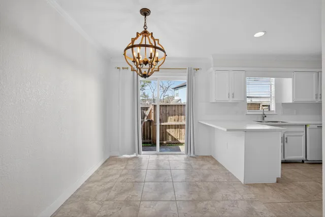 a view of a kitchen with a sink wooden cabinets and a window