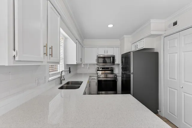 a kitchen with stainless steel appliances granite countertop a refrigerator sink and stove