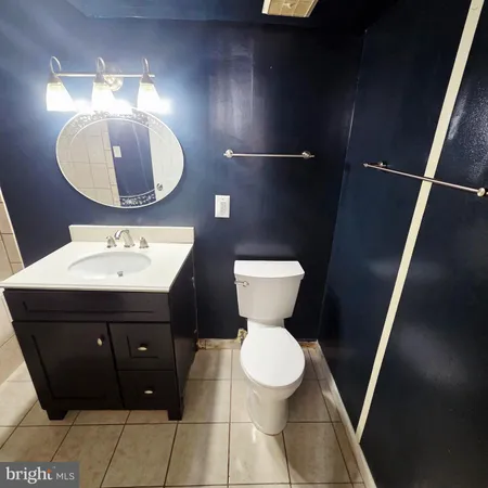 a bathroom with a toilet sink vanity granite and mirror