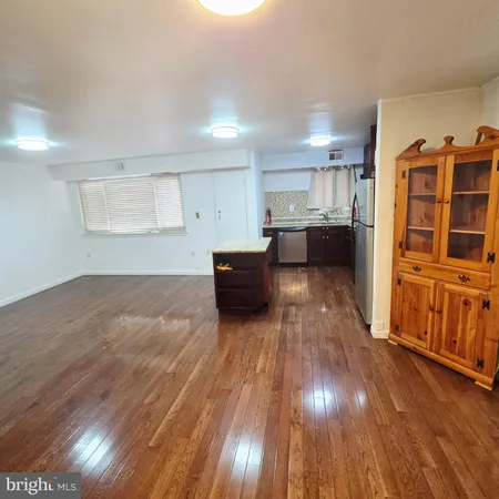 a view of a kitchen with wooden floor and cabinets