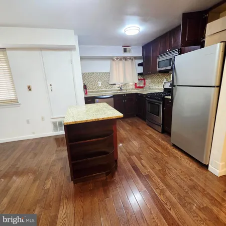 a kitchen with stainless steel appliances granite countertop a refrigerator sink and white cabinets