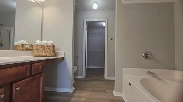 a bathroom with a granite countertop sink and a bathtub