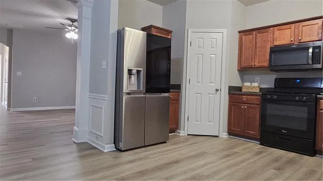 a view of a kitchen with a refrigerator a microwave and cabinets