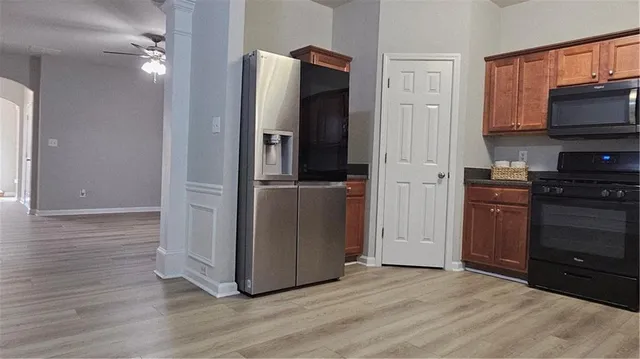 a view of a kitchen with a refrigerator a stove top oven and cabinets